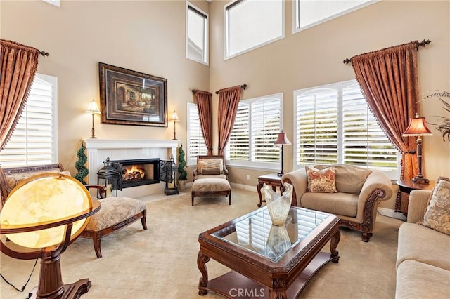 interior space with a towering ceiling, a fireplace, and light carpet