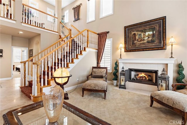 living room featuring a towering ceiling and a tile fireplace