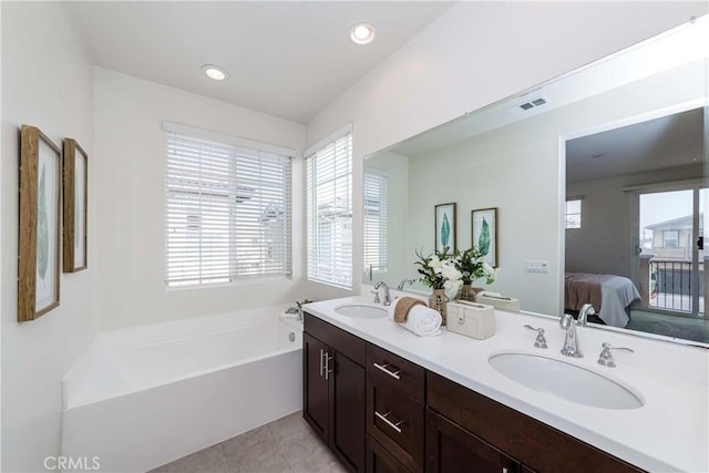 bathroom with vanity, a bathing tub, and tile patterned flooring