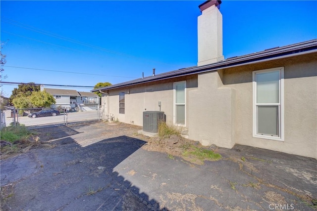 view of side of home featuring central AC unit and a patio