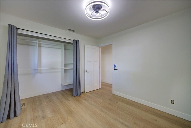 unfurnished bedroom with a closet and light hardwood / wood-style flooring