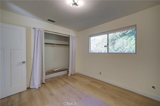 unfurnished bedroom featuring a closet and light hardwood / wood-style flooring