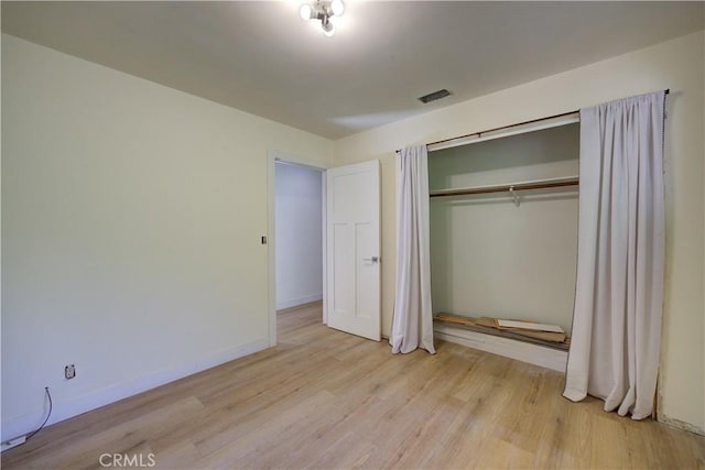 unfurnished bedroom with a closet and light hardwood / wood-style flooring