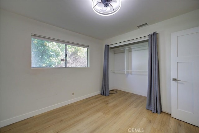 unfurnished bedroom featuring light hardwood / wood-style floors and a closet