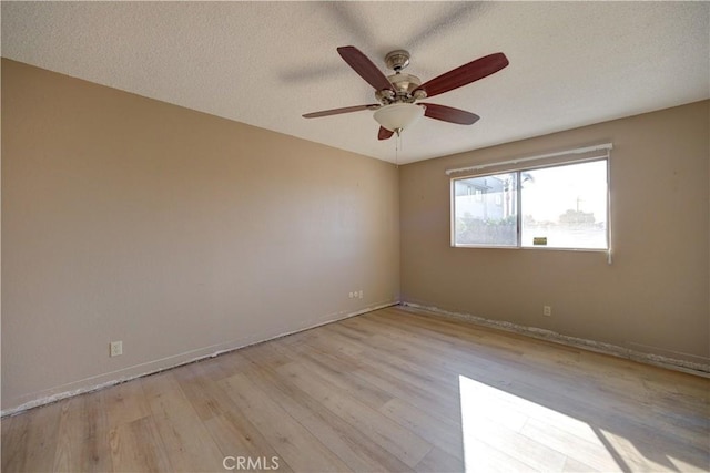 unfurnished room with ceiling fan, a textured ceiling, and light hardwood / wood-style flooring