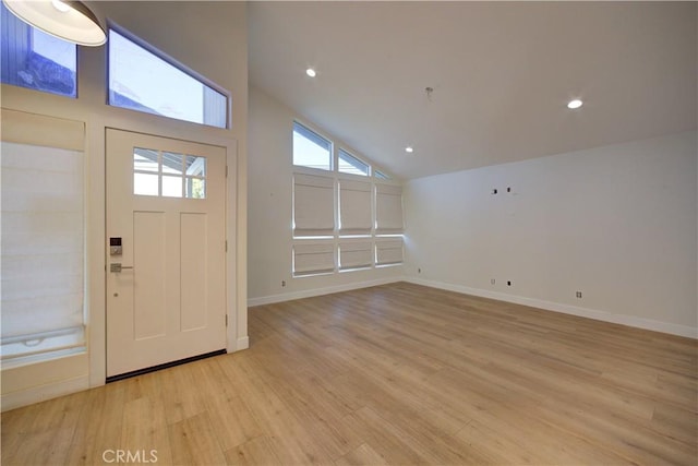 entryway featuring high vaulted ceiling and light wood-type flooring