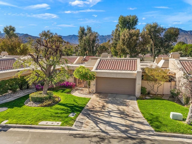 mediterranean / spanish-style home featuring a mountain view, a front lawn, and a garage