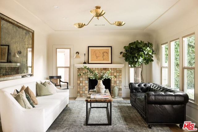 living room with a tile fireplace and dark hardwood / wood-style flooring