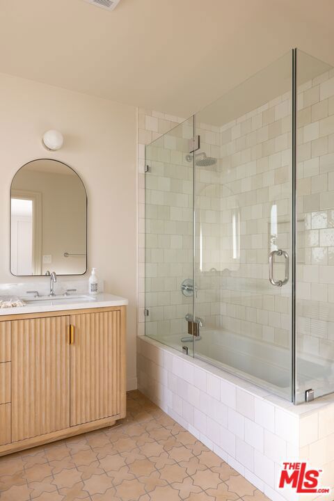 bathroom with bath / shower combo with glass door, tile patterned flooring, and vanity