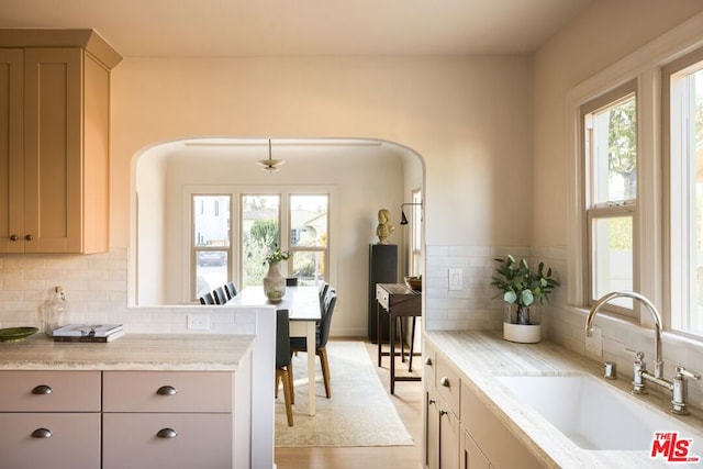 kitchen featuring decorative backsplash, plenty of natural light, and sink