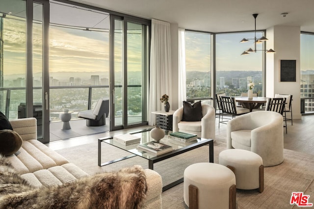 living room featuring light wood-type flooring, a healthy amount of sunlight, and floor to ceiling windows