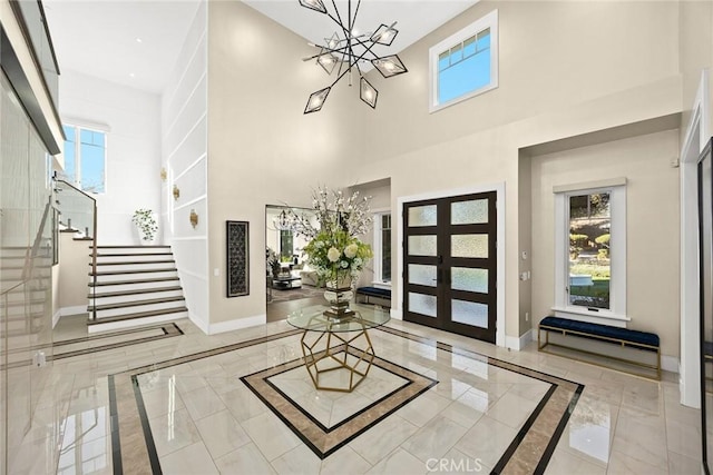 foyer featuring french doors and a notable chandelier