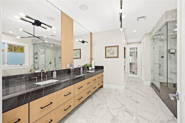 bathroom featuring a shower with door, an inviting chandelier, and vanity