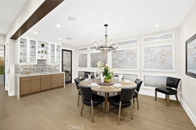 dining area with a chandelier, light hardwood / wood-style flooring, and sink