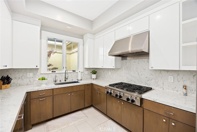 kitchen with extractor fan, sink, white cabinetry, stainless steel gas cooktop, and light stone counters