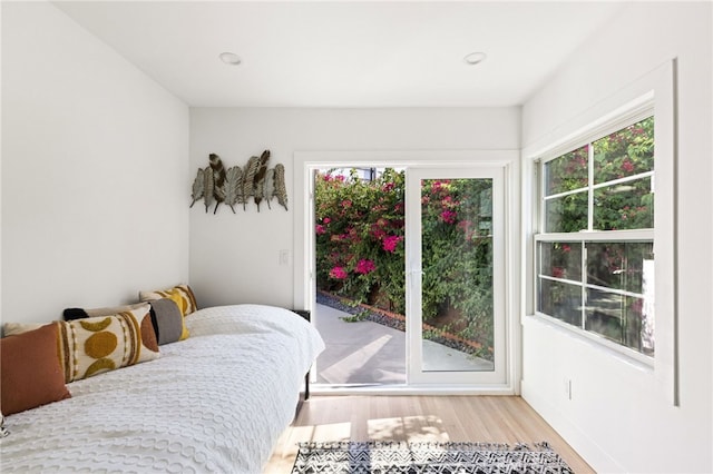 bedroom with multiple windows and light hardwood / wood-style flooring