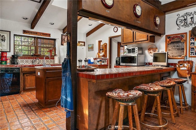 kitchen with tasteful backsplash, dishwasher, vaulted ceiling with beams, a breakfast bar, and tile counters