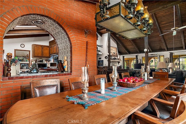 dining room featuring ceiling fan, beam ceiling, wood ceiling, high vaulted ceiling, and brick wall