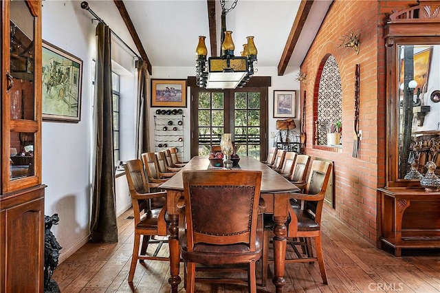 dining room with french doors, a chandelier, hardwood / wood-style floors, and beamed ceiling