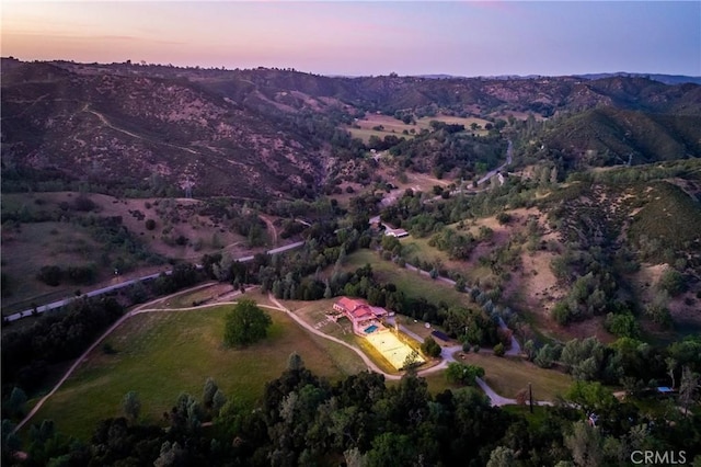 aerial view at dusk featuring a mountain view