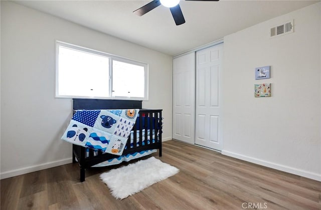 bedroom with ceiling fan, a closet, and hardwood / wood-style flooring