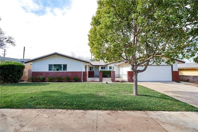 ranch-style home featuring a garage and a front lawn