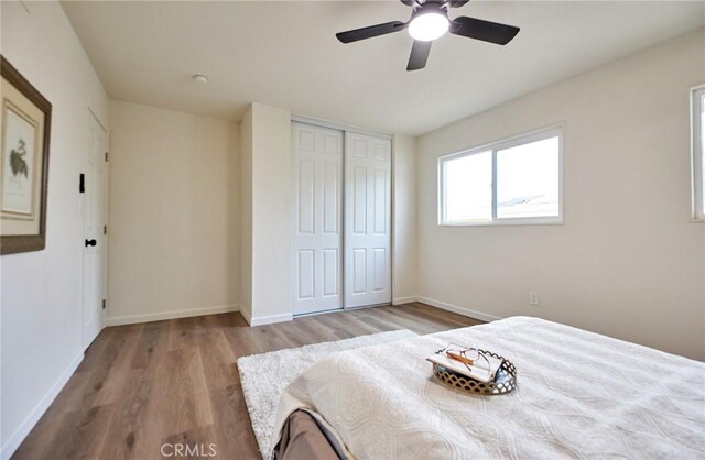 unfurnished bedroom with ceiling fan, light hardwood / wood-style floors, and a closet