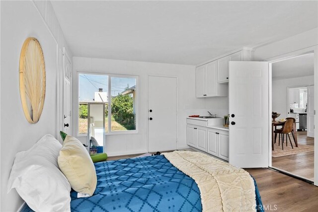 bedroom with sink, connected bathroom, and hardwood / wood-style floors