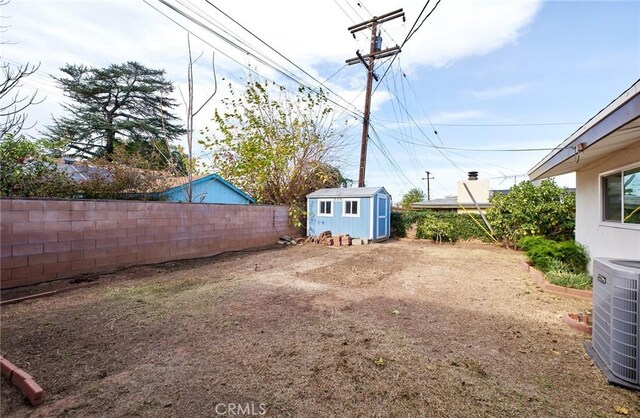 view of yard with central AC and a shed