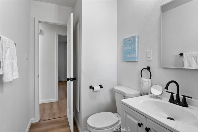 bathroom featuring hardwood / wood-style floors, toilet, and vanity