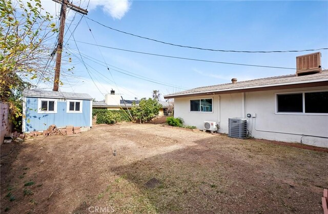 view of yard with cooling unit and a storage shed