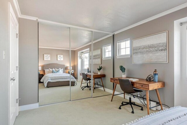 bedroom with ornamental molding and light colored carpet