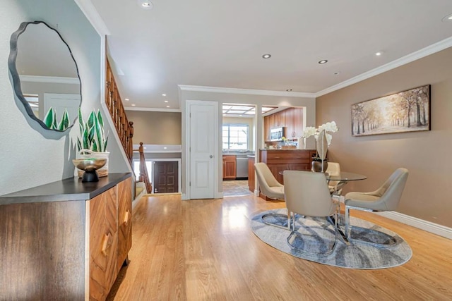 dining space with light hardwood / wood-style floors and ornamental molding