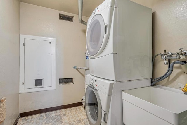 laundry room with sink and stacked washer / dryer