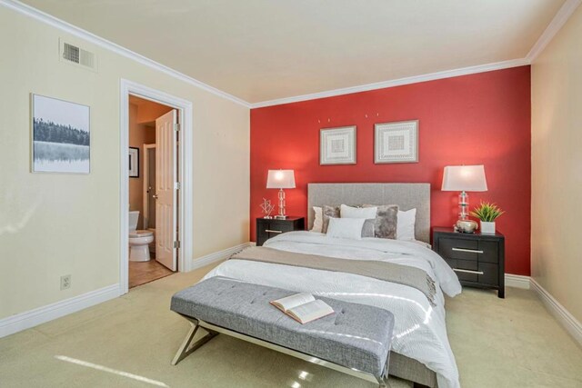 bedroom with light colored carpet, ensuite bathroom, and ornamental molding