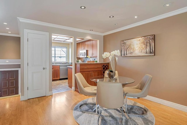 dining room featuring crown molding and light wood-type flooring