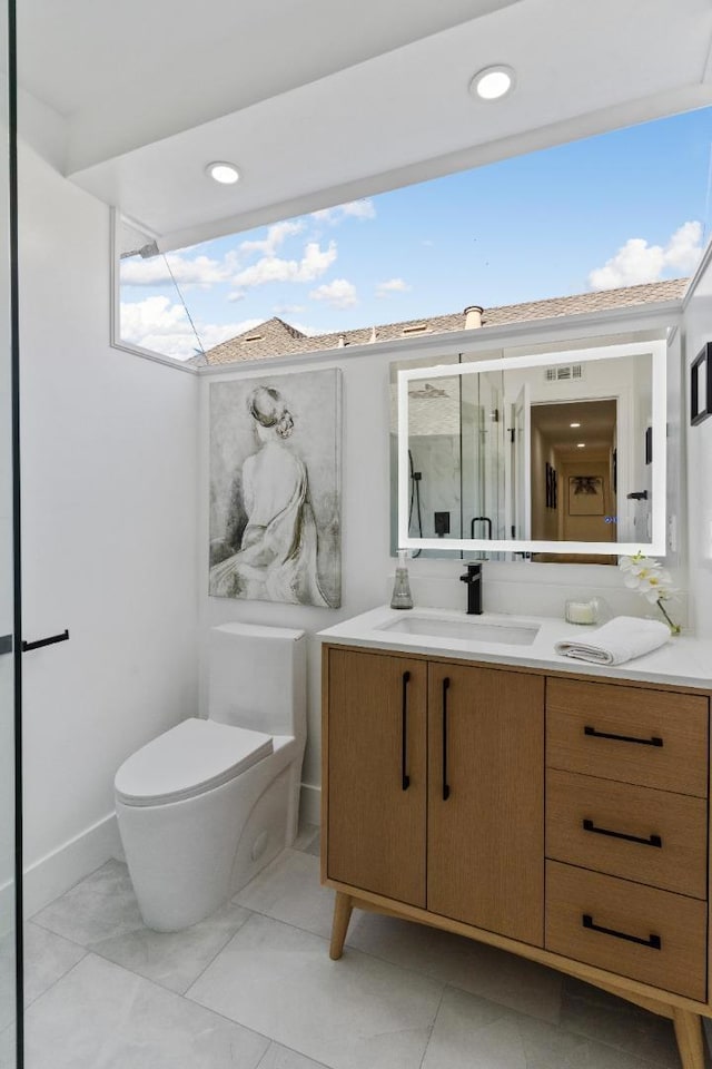 bathroom featuring toilet, vanity, a shower with door, and a healthy amount of sunlight