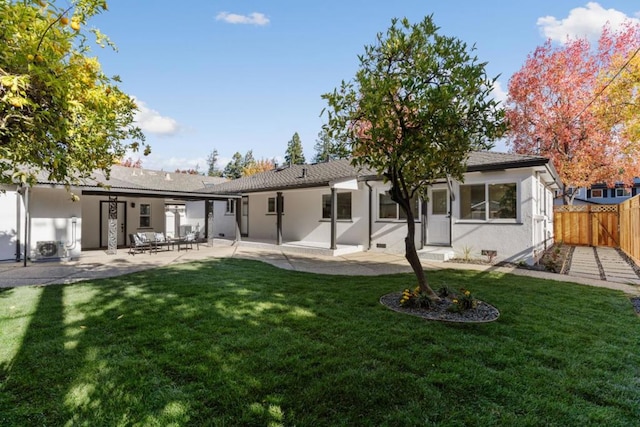 back of property with a patio area and a yard