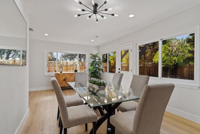 dining space featuring a chandelier, light hardwood / wood-style floors, and french doors