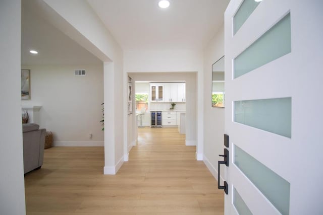 corridor featuring beverage cooler and light hardwood / wood-style flooring