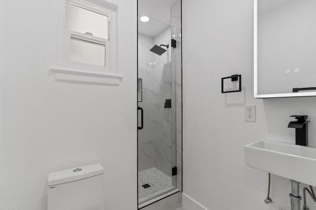 bathroom with sink, toilet, and an enclosed shower