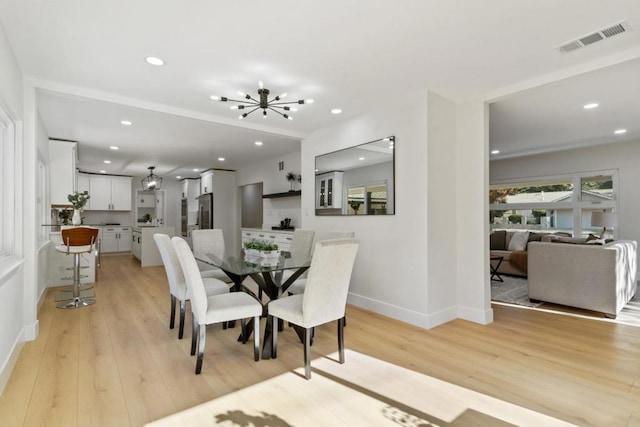 dining area featuring a notable chandelier and light hardwood / wood-style floors