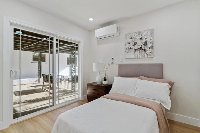 bedroom featuring an AC wall unit, access to exterior, and wood-type flooring