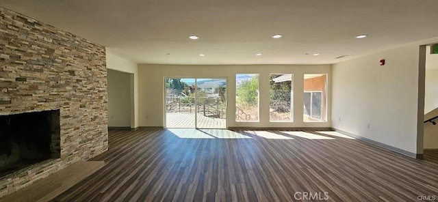 unfurnished living room featuring a stone fireplace