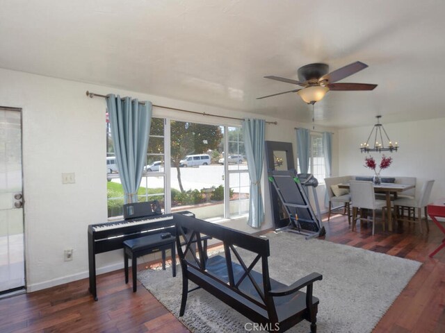 living room with dark wood-type flooring and ceiling fan