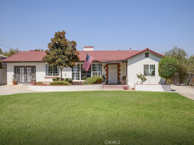 view of front of home with a front lawn and french doors