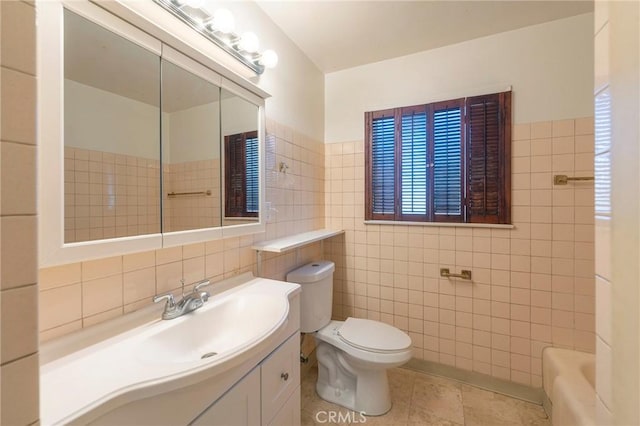 bathroom featuring toilet, a tub, tile walls, tile patterned floors, and vanity