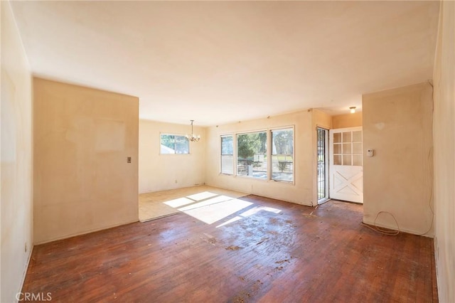 empty room with an inviting chandelier and hardwood / wood-style flooring