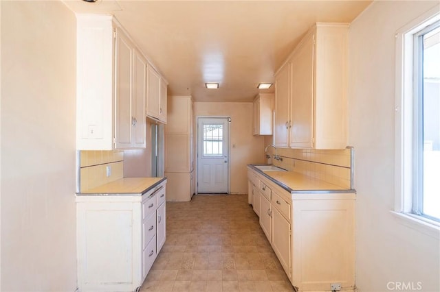 kitchen with white cabinets, sink, and tasteful backsplash