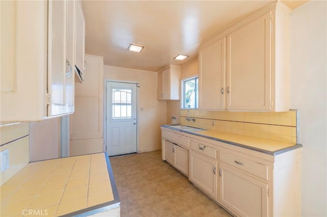 kitchen with white cabinets, tasteful backsplash, and sink